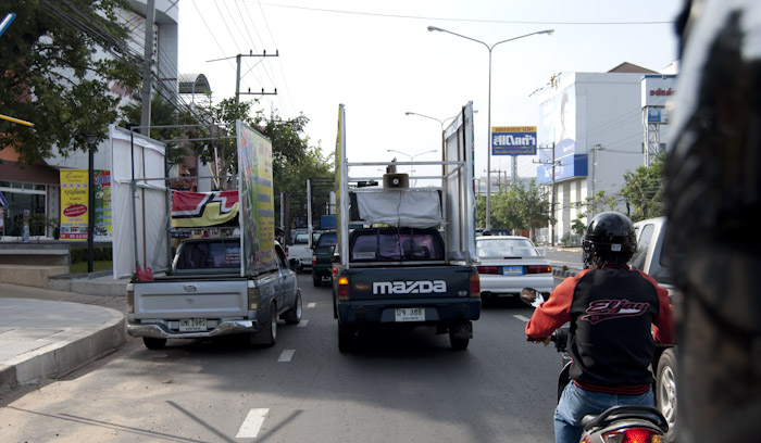 trucks with signs and speakers in traffic