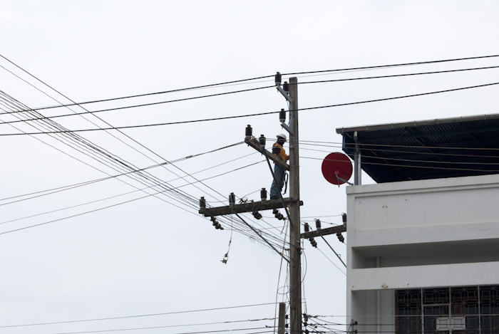 worker on utility pole arm